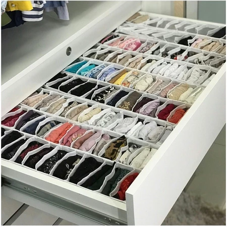 Duas colmeias organizadoras flexíveis de TNT branco com várias camisetas dobradas de forma alinhada dentro de uma gaveta